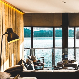 View from a living room looking out a large window towards a large body of water.